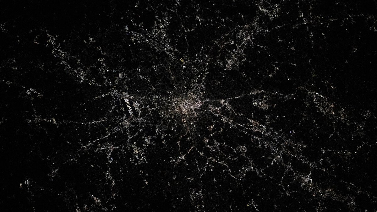 Atlanta photographed from the International Space Station in 2025, neighborhoods spread through heavy tree cover