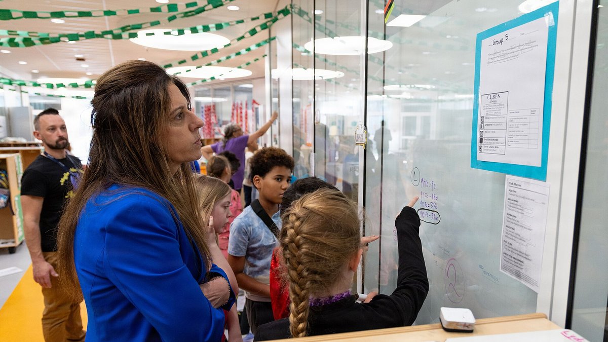 Students working together at a glass wall in a bright modern school