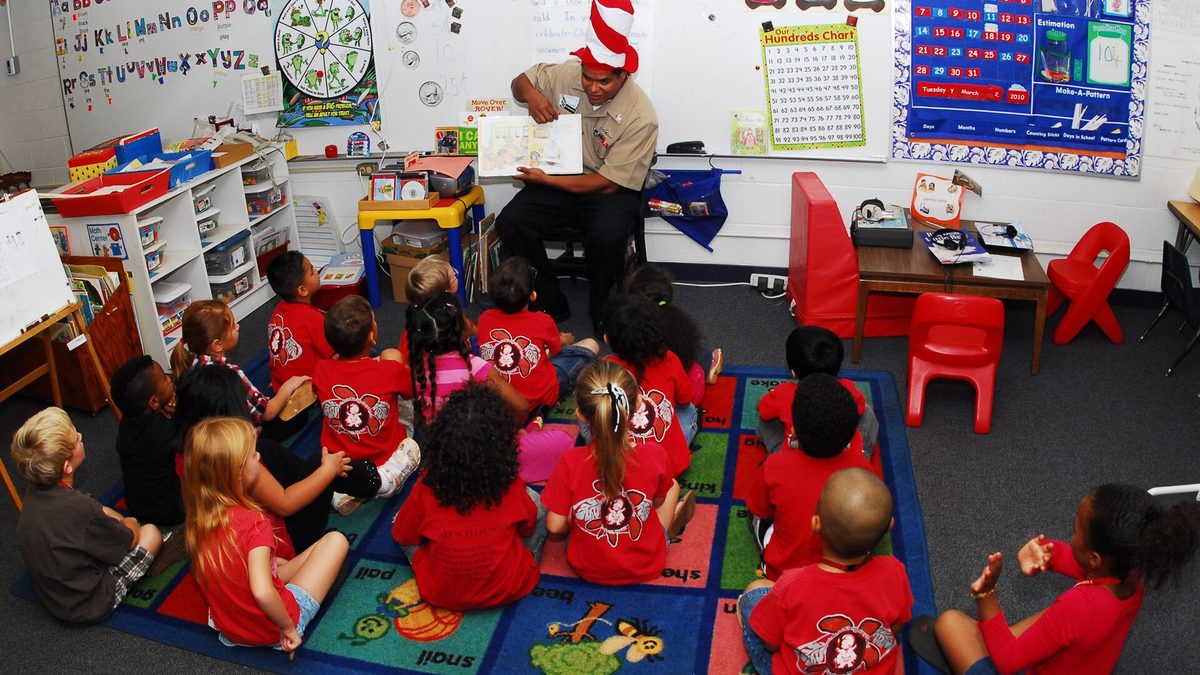 A sailor reading aloud to a kindergarten class